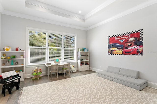 rec room featuring ornamental molding, a tray ceiling, wood finished floors, recessed lighting, and baseboards