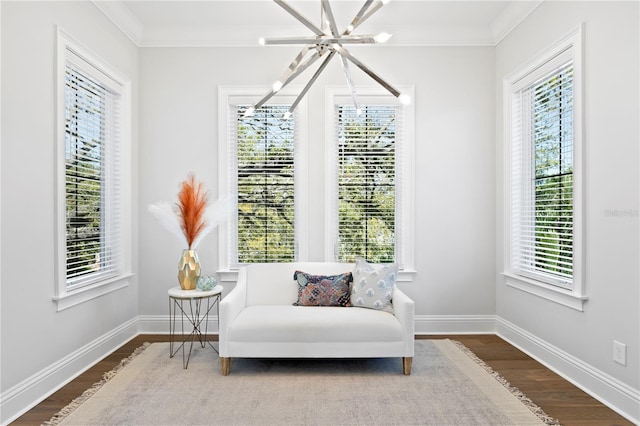 living area with a healthy amount of sunlight, wood finished floors, and crown molding