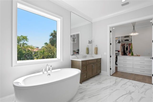 bathroom with vanity, visible vents, a freestanding bath, ornamental molding, and marble finish floor