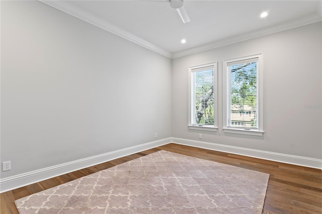 unfurnished room with crown molding, baseboards, and dark wood-style flooring