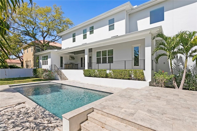 back of house featuring stucco siding, a fenced in pool, and fence