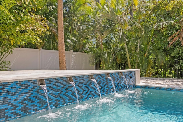 view of pool featuring fence