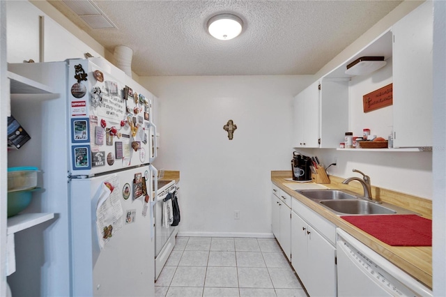 kitchen featuring visible vents, white appliances, a textured ceiling, white cabinetry, and a sink