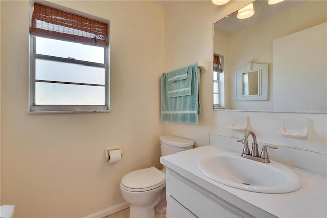 bathroom with vanity, baseboards, and toilet