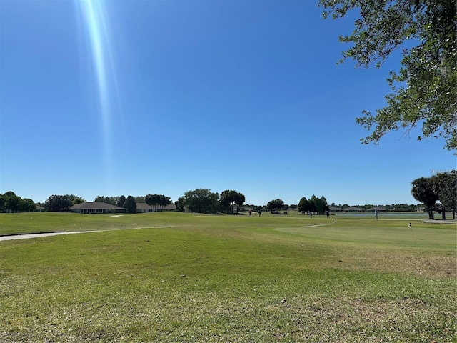 view of home's community with a yard and view of golf course