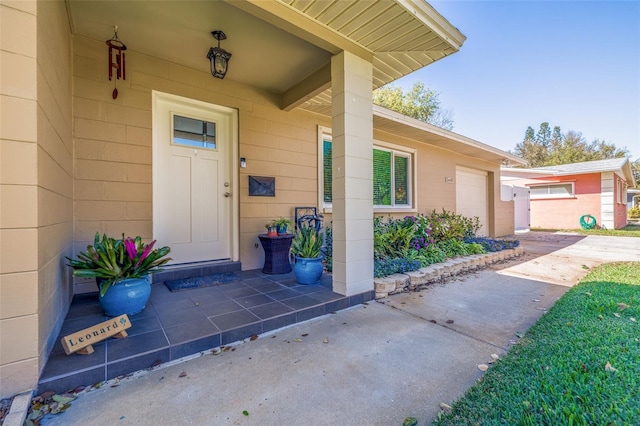 view of exterior entry with driveway and concrete block siding