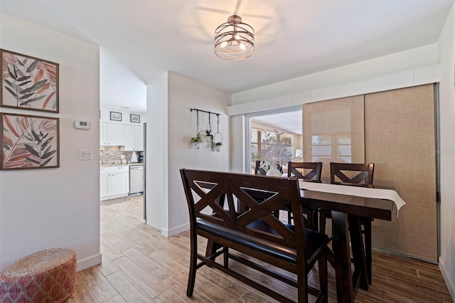 dining space with light wood-type flooring and baseboards