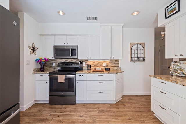 kitchen featuring light wood finished floors, visible vents, backsplash, and appliances with stainless steel finishes