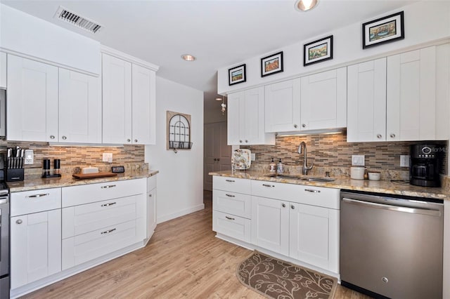 kitchen with visible vents, white cabinetry, a sink, stainless steel dishwasher, and light wood-type flooring