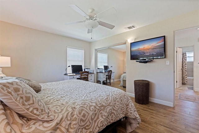 bedroom with ceiling fan, visible vents, baseboards, and wood finished floors