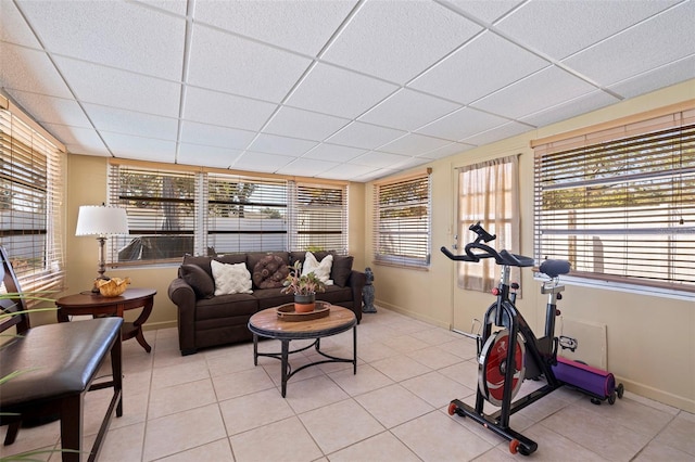 exercise room featuring a wealth of natural light, baseboards, a paneled ceiling, and light tile patterned floors