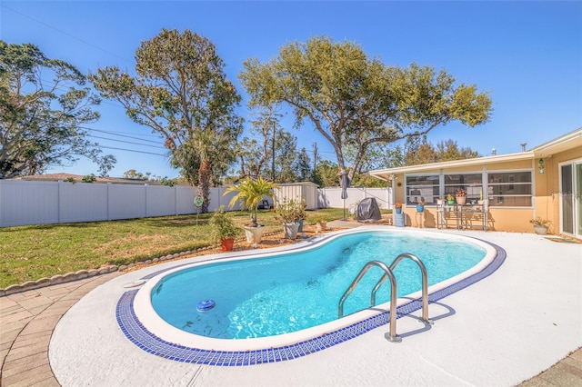 view of pool featuring an outbuilding, a patio, a fenced backyard, a yard, and a fenced in pool