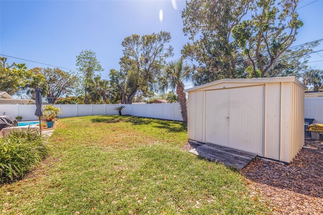 view of yard featuring a fenced in pool, a storage unit, a fenced backyard, and an outdoor structure