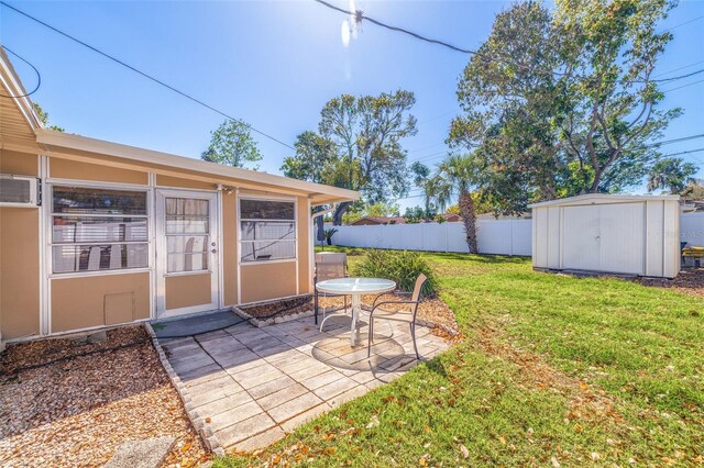 view of yard featuring a patio area, a shed, fence, and an outdoor structure