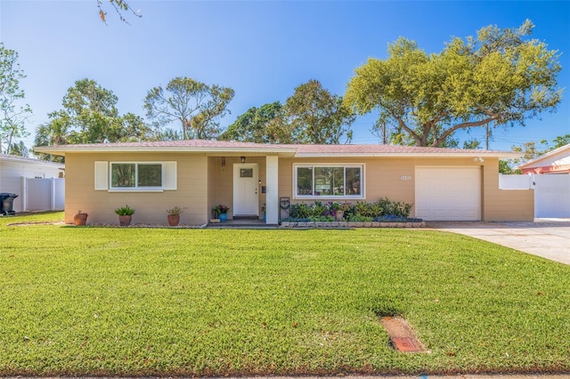 ranch-style home featuring a front yard, concrete driveway, a garage, and fence