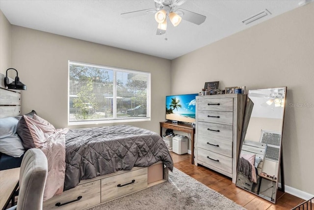 bedroom featuring visible vents, ceiling fan, and wood finished floors