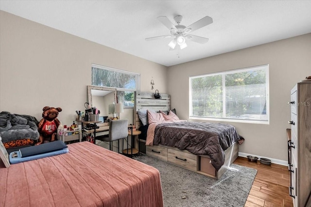 bedroom featuring a ceiling fan, baseboards, and wood finished floors