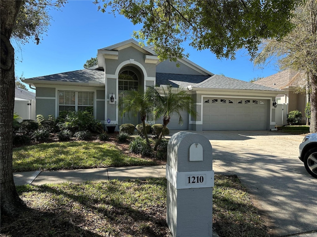 view of front of house featuring a garage, concrete driveway, and stucco siding