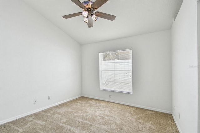 empty room with lofted ceiling, light colored carpet, baseboards, and ceiling fan