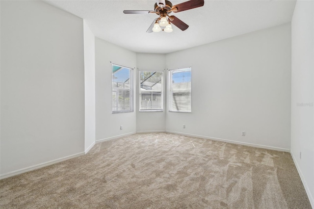 spare room featuring carpet, baseboards, and ceiling fan