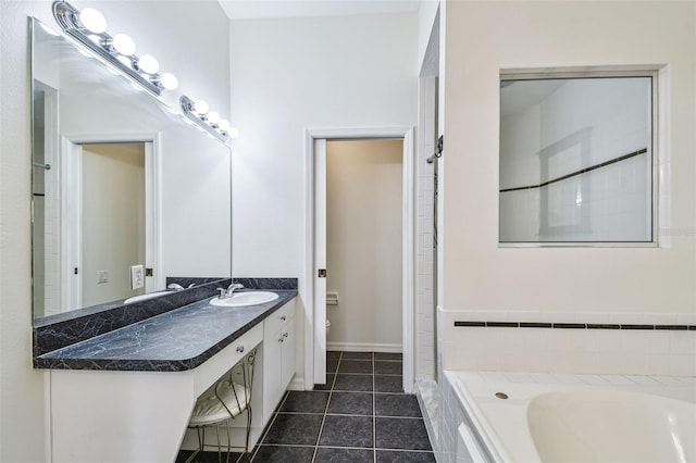 full bathroom featuring tile patterned floors, toilet, baseboards, a bathtub, and vanity