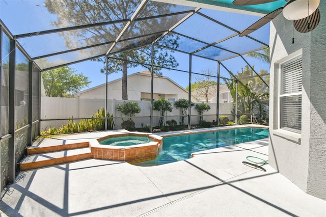 view of pool featuring glass enclosure, a pool with connected hot tub, a fenced backyard, and a patio area