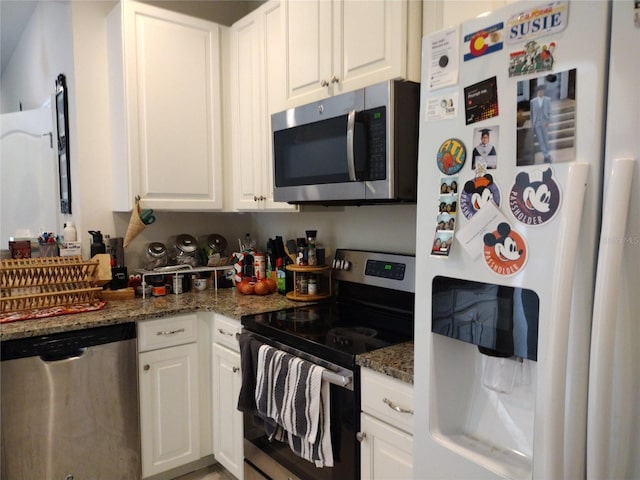 kitchen with white cabinetry, dark stone countertops, and appliances with stainless steel finishes