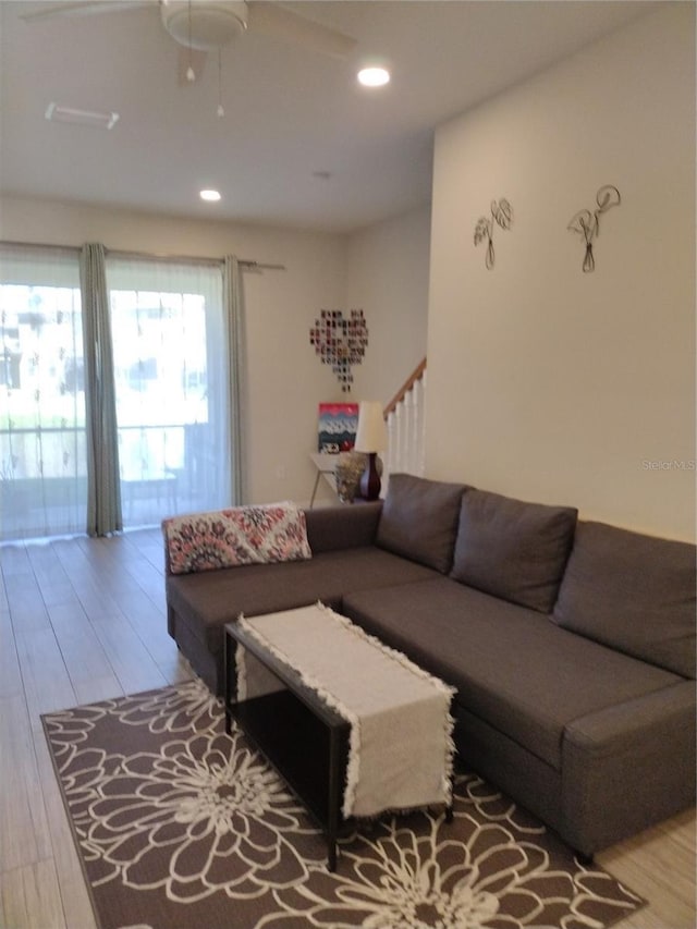 living room with recessed lighting, stairs, and light wood-type flooring