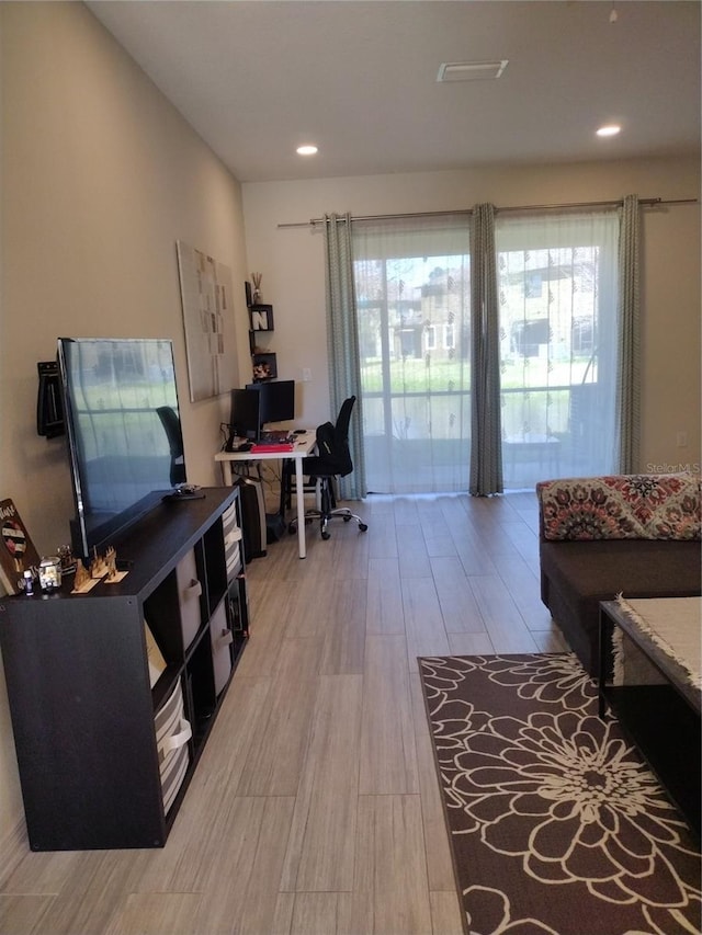 home office featuring recessed lighting, a healthy amount of sunlight, and light wood-style flooring