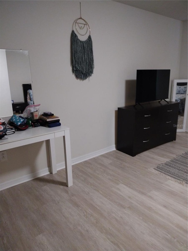 office area featuring baseboards and light wood finished floors