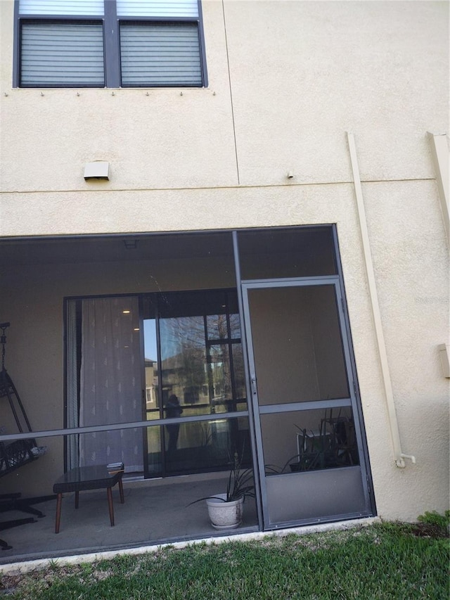 rear view of property featuring stucco siding