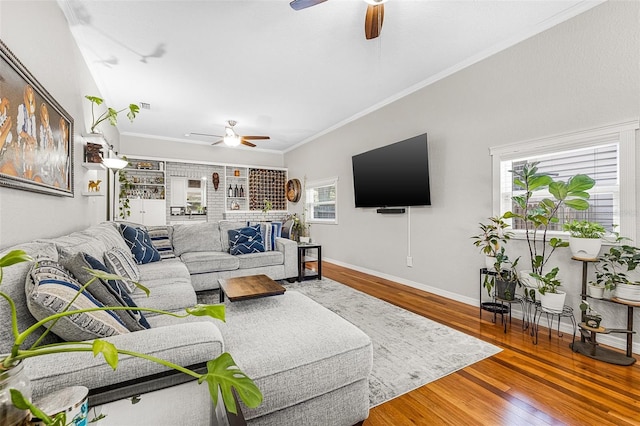 living room featuring baseboards, crown molding, a ceiling fan, and hardwood / wood-style flooring