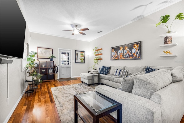 living area featuring visible vents, a ceiling fan, wood finished floors, crown molding, and baseboards