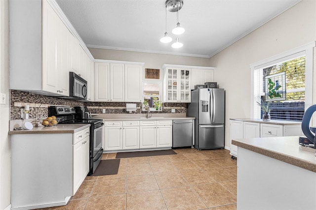 kitchen with decorative backsplash, crown molding, white cabinets, and stainless steel appliances