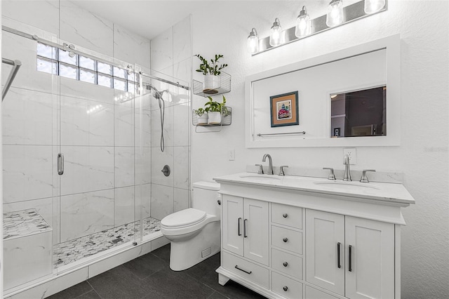 full bathroom featuring double vanity, a stall shower, toilet, and a sink