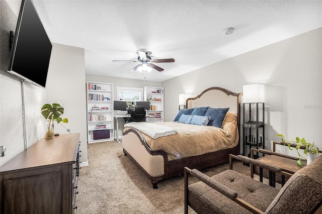 bedroom featuring a ceiling fan, light colored carpet, a textured wall, and a textured ceiling