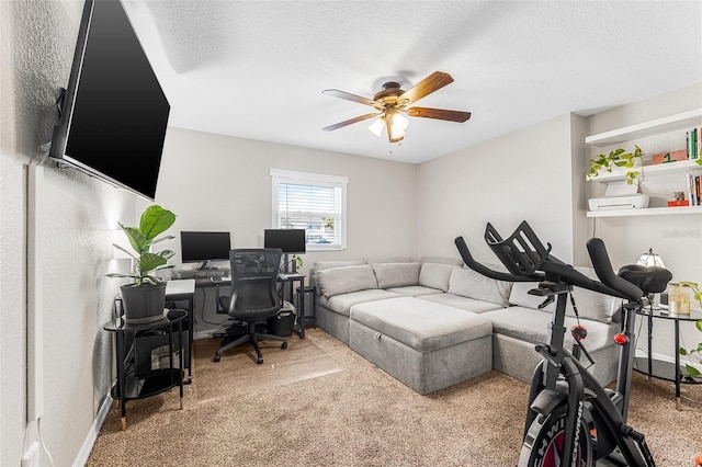 office area featuring carpet flooring, baseboards, a textured ceiling, and a ceiling fan