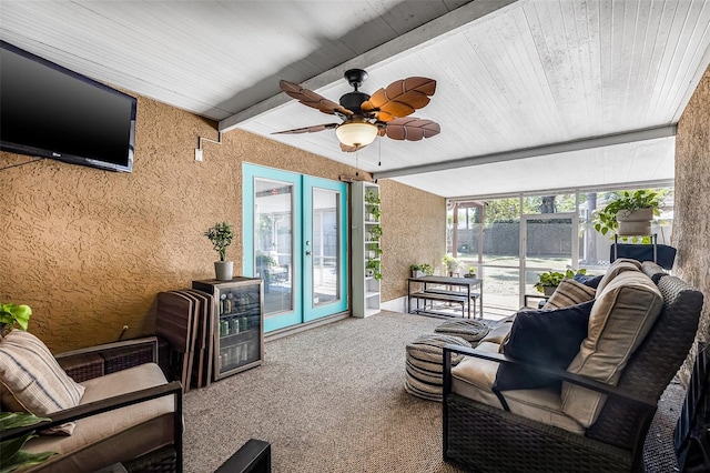 sunroom / solarium featuring beam ceiling and ceiling fan