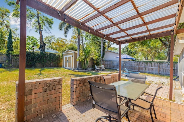 view of patio / terrace with an outbuilding, a pergola, a fenced backyard, a shed, and outdoor dining area