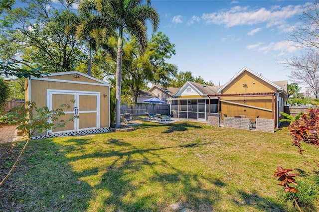 view of yard with a fenced backyard, a sunroom, an outdoor structure, a storage shed, and a patio area