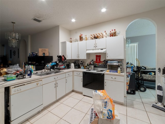 kitchen featuring range with electric cooktop, under cabinet range hood, light countertops, white dishwasher, and arched walkways