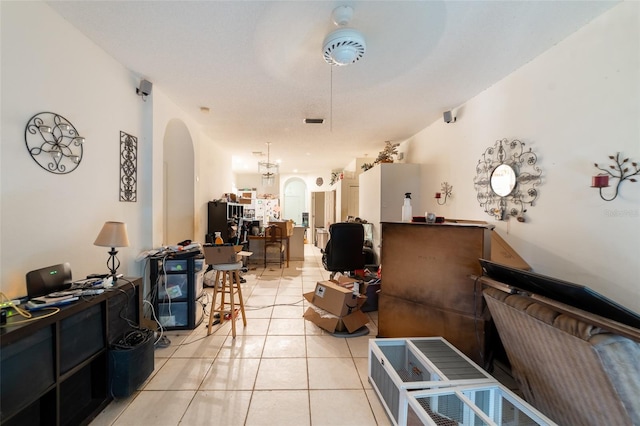 misc room with arched walkways and light tile patterned floors