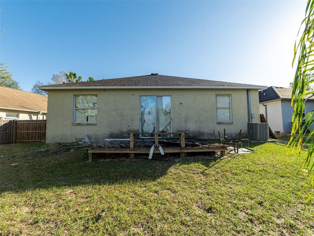 back of house with fence, a wooden deck, central AC unit, a lawn, and stucco siding