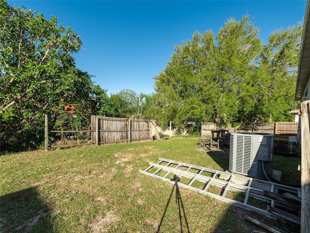 view of yard featuring central AC unit and a fenced backyard