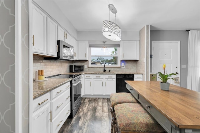 kitchen with butcher block countertops, white cabinets, stainless steel appliances, and a sink