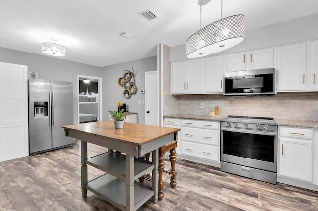 kitchen featuring tasteful backsplash, visible vents, appliances with stainless steel finishes, and white cabinetry