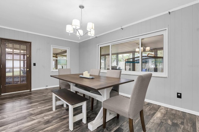 dining space with an inviting chandelier, baseboards, crown molding, and dark wood-type flooring