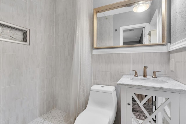 bathroom featuring tile walls, tiled shower, toilet, and vanity