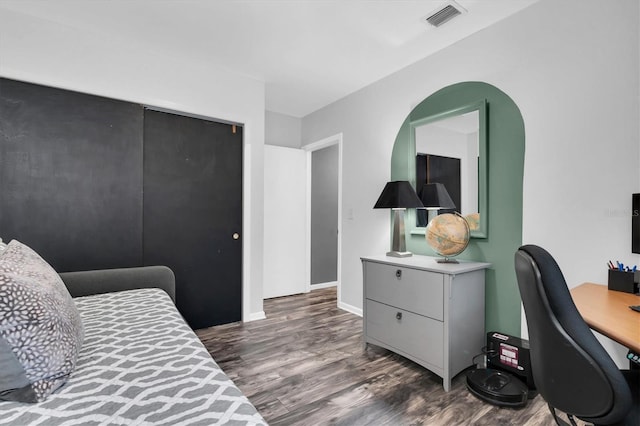 bedroom featuring wood finished floors, visible vents, and baseboards