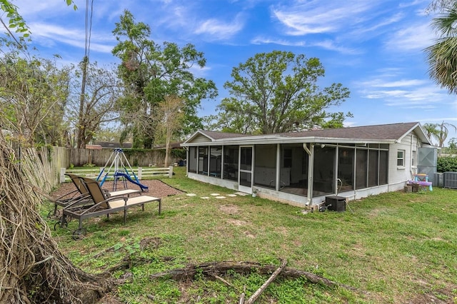 back of house with central air condition unit, a lawn, a fenced backyard, and a sunroom